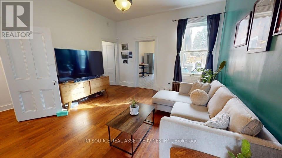 A living room with a flat screen TV and a white sofa.