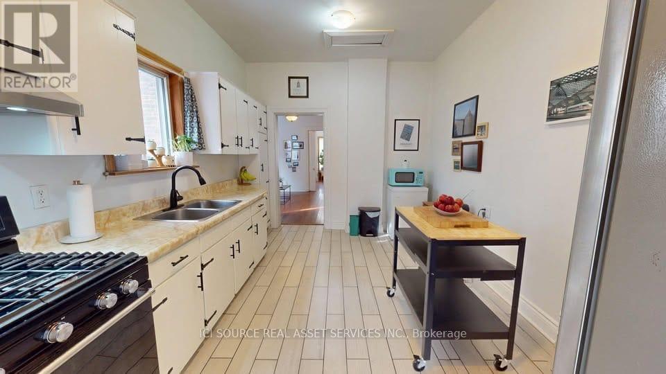 A kitchen with a black stove top oven and white cabinets.