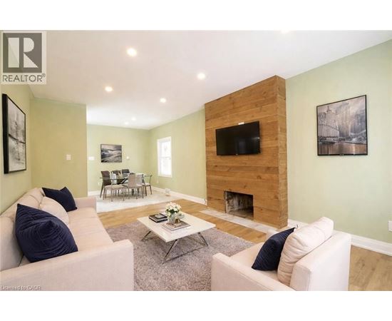 A living room with a fireplace and a flat screen TV.
