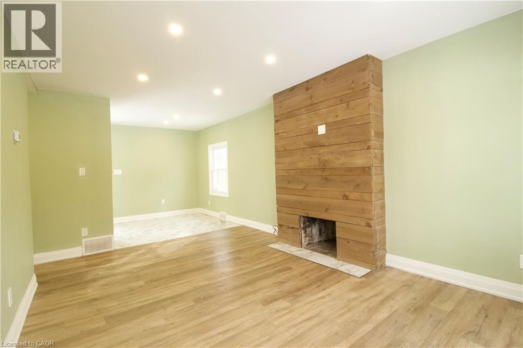 A room with a wood fireplace and green walls.