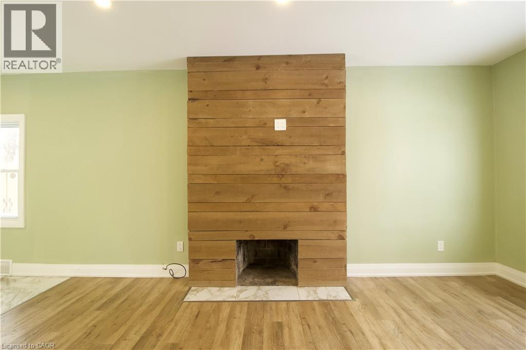 A wood fireplace in a room with green walls.