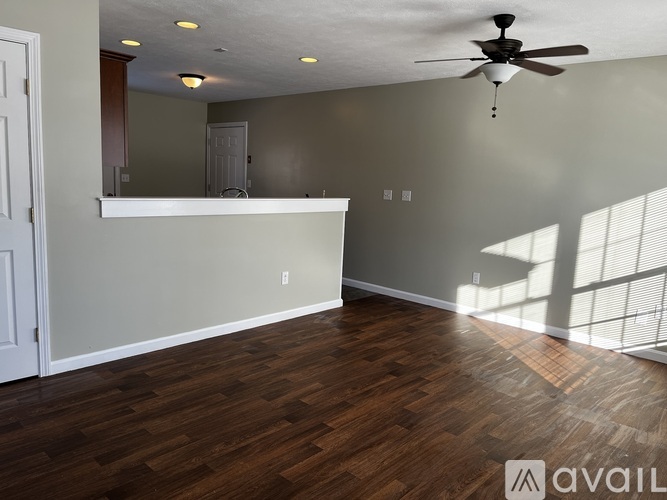 A room with wooden flooring and a ceiling fan.