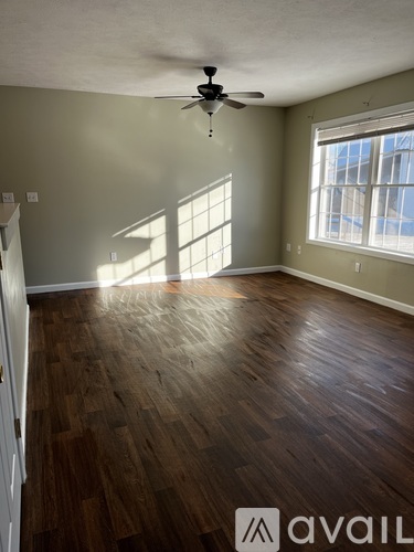A room with wooden flooring and a ceiling fan.