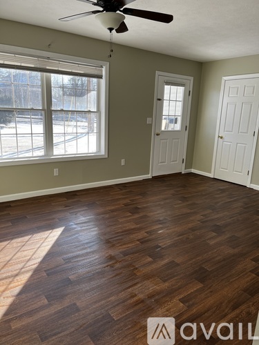 A room with a ceiling fan and two doors.