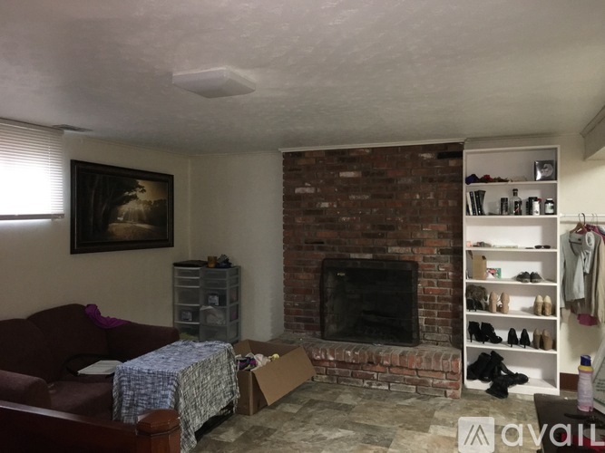 A living room with a fireplace and a painting on the wall.