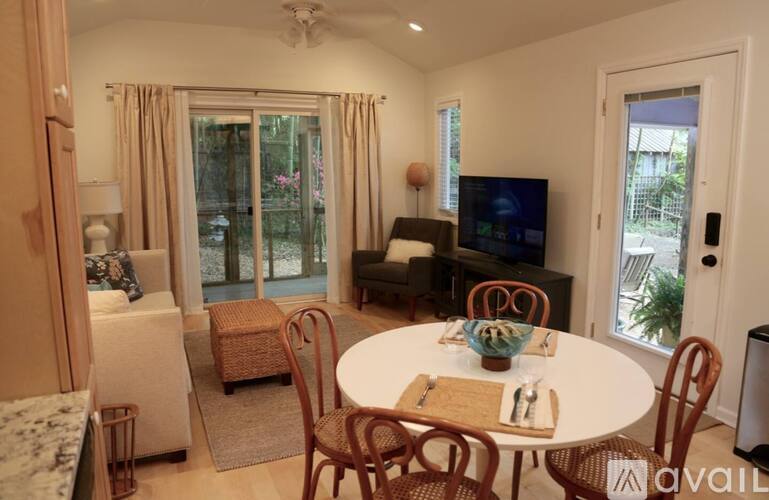 A dining room with a table set for two and a television.