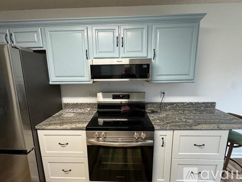 A kitchen with a granite countertop and a stove top oven.