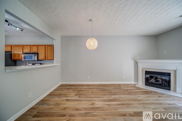 A living room with a fireplace and wooden floors.