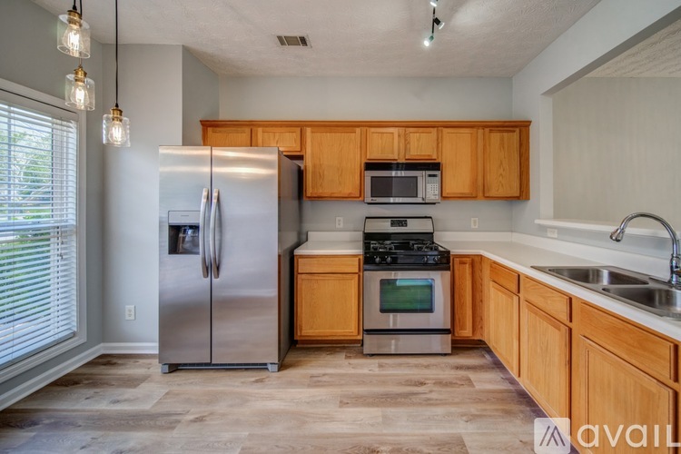 A kitchen with wooden cabinets and a stainless steel refrigerator.