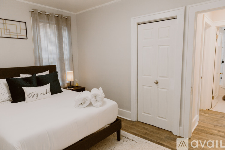 A bedroom with a bed, nightstand, and a door.