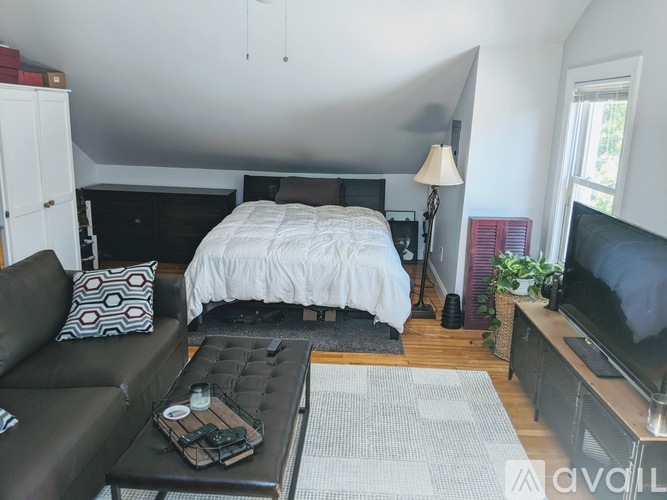 A bedroom with a bed, couch, and television.