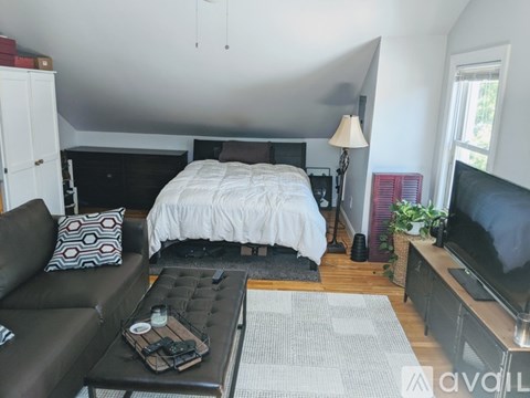A bedroom with a bed, couch, and television.