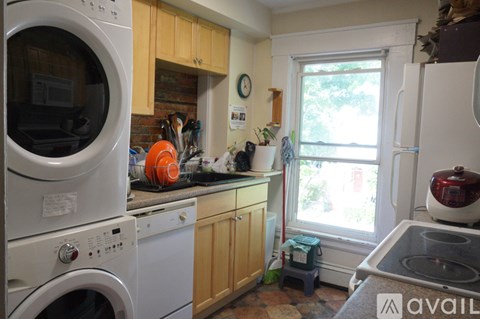 A kitchen with a washer and dryer stacked on top of each other.