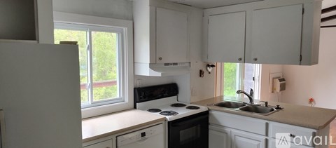 A kitchen with white cabinets and a window.