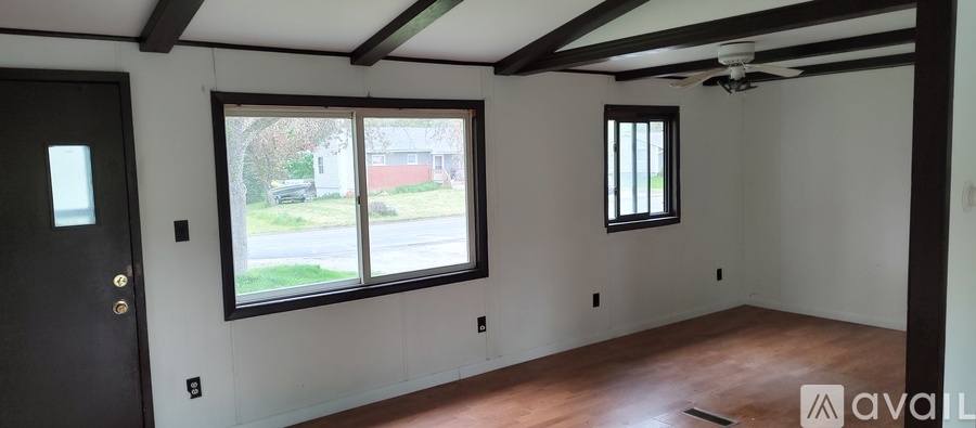 A room with a black door and two windows.