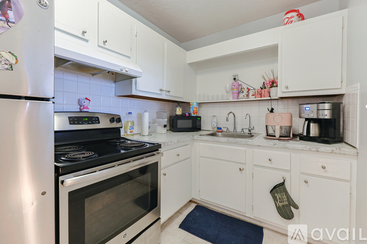 A kitchen with white cabinets and appliances.