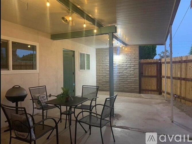 A patio with a table and chairs is set up outside a house.