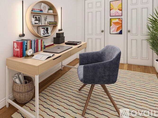 A home office with a desk, chair, and a round mirror on the wall.