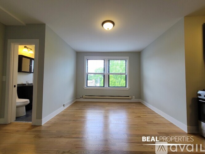 A room with a window and a wooden floor.