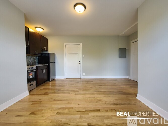 A kitchen with wooden floors and white walls.