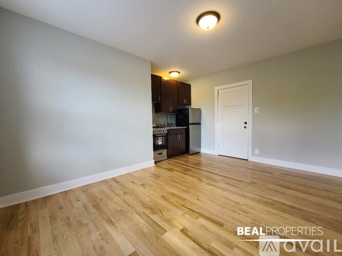 A room with wooden flooring and a white door.
