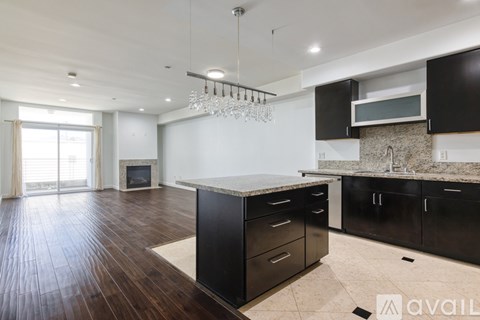 A modern kitchen with black cabinets and a central island.