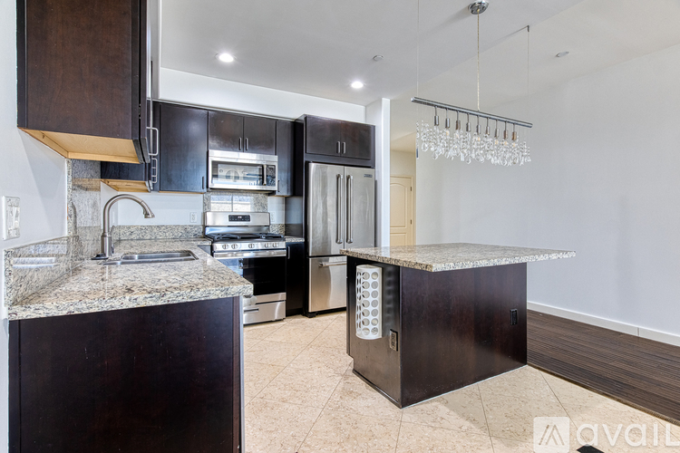 A kitchen with a granite countertop and stainless steel appliances.