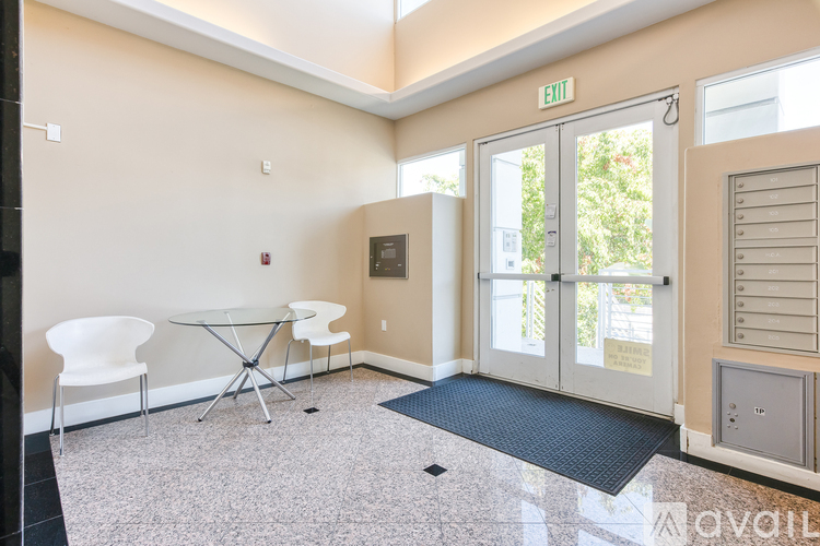 A room with a glass table and chairs with a white exterior door.