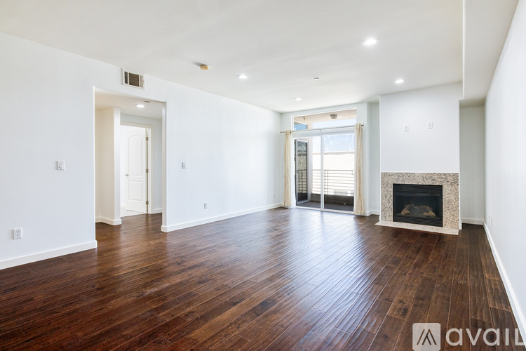 A spacious living room with a fireplace and hardwood floors.
