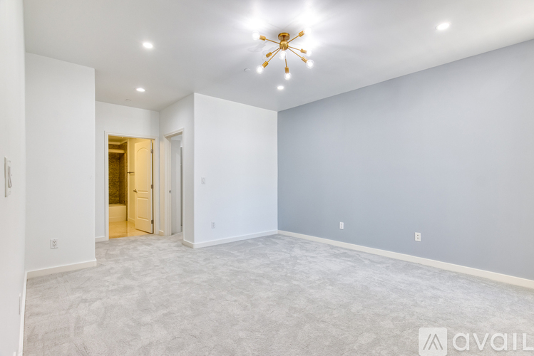 A spacious room with a ceiling fan and carpeted floor.