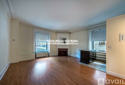 A spacious living room with hardwood floors and a fireplace.