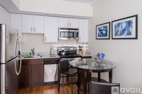 A kitchen with white cabinets and a refrigerator.