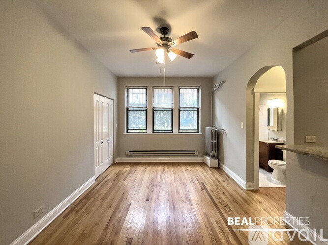 A spacious room with a ceiling fan and wooden flooring.