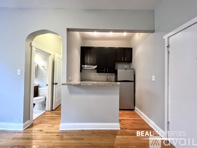 A kitchen with a white island and wooden floors.