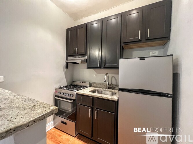 A kitchen with granite countertops and a stainless steel refrigerator.