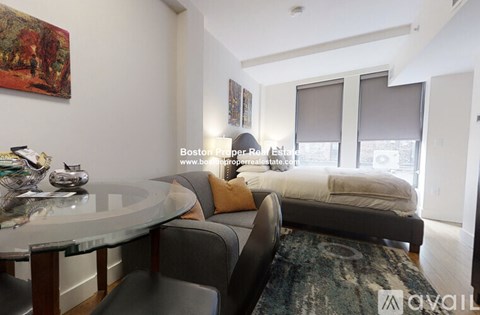 A living room with a couch, a table, and a painting on the wall.