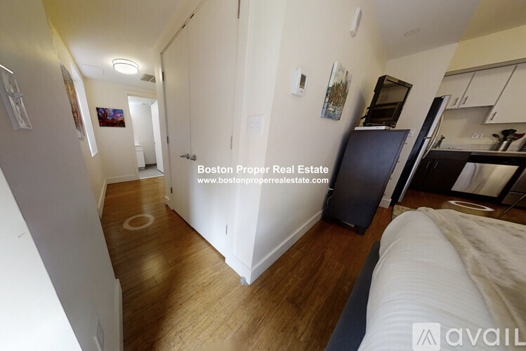 A kitchen area with a refrigerator, cabinets, and a countertop.