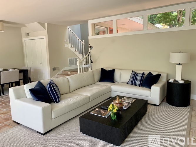 A living room with a white couch and a black coffee table.