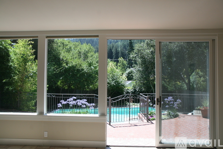 A view of a pool through a sliding glass door.