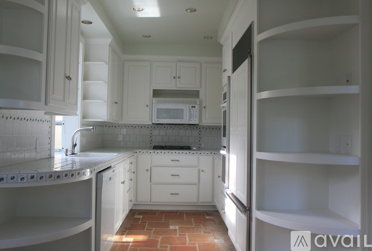 A kitchen with white cabinets and a tiled backsplash.