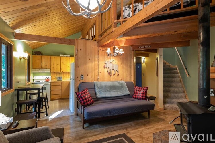 A living room with a couch and a staircase.