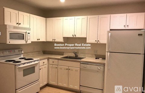 A kitchen with white appliances and cabinets.