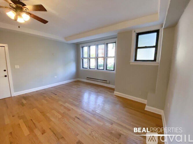 A room with wooden flooring and a ceiling fan.
