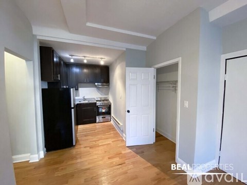 A kitchen with black appliances and wooden floors.