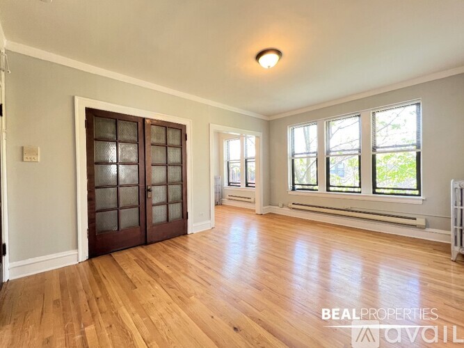 A room with wooden floors and a large window.