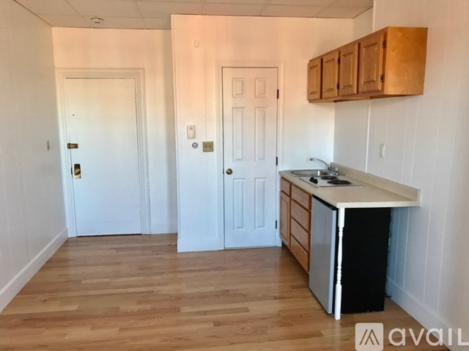 A kitchen with a white countertop and wooden floors.