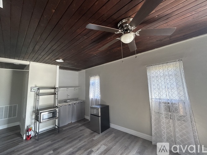 A kitchen with a wooden ceiling and a fan.