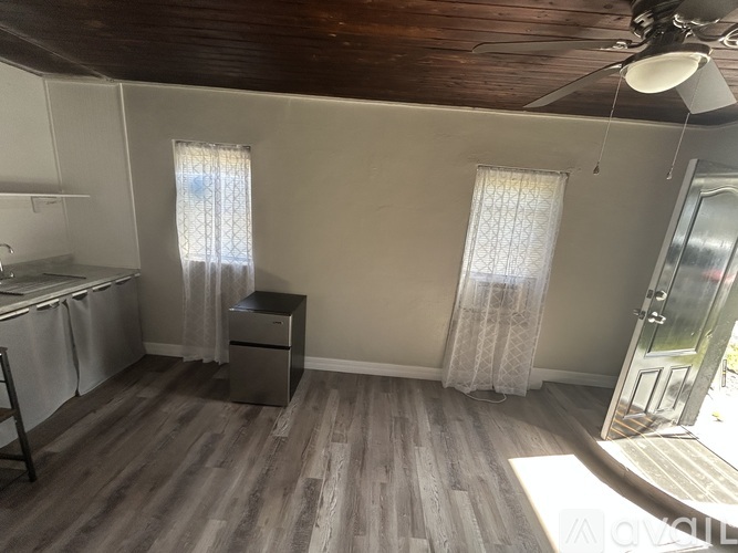 A room with wooden floors and a ceiling fan.