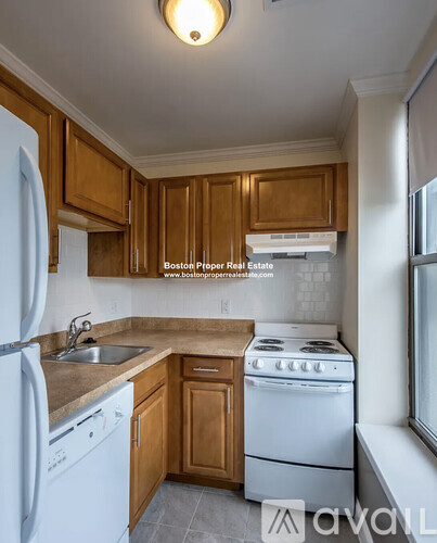 A kitchen with wooden cabinets and white appliances.