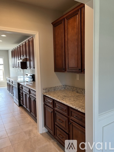A kitchen with brown cabinets and granite countertops.